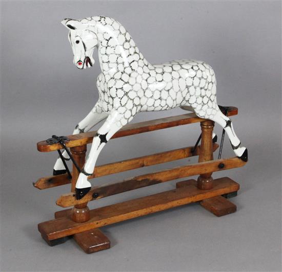 An Edwardian dapple painted wood rocking horse, L.3ft H.2ft 9in.